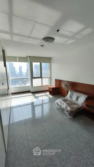 Spacious living room with city view and modern design in high-rise apartment.