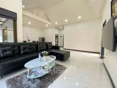 Spacious modern living room with sleek black sofa and elegant decor