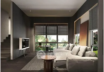 Modern living room with large windows and stylish decor, featuring a cozy sofa and a sleek TV stand.
