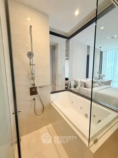 Luxurious modern bathroom with glass walls and bathtub overlooking elegant bedroom.