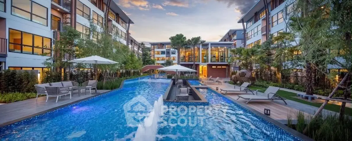 Luxurious apartment complex with stunning pool and lush landscaping at sunset.