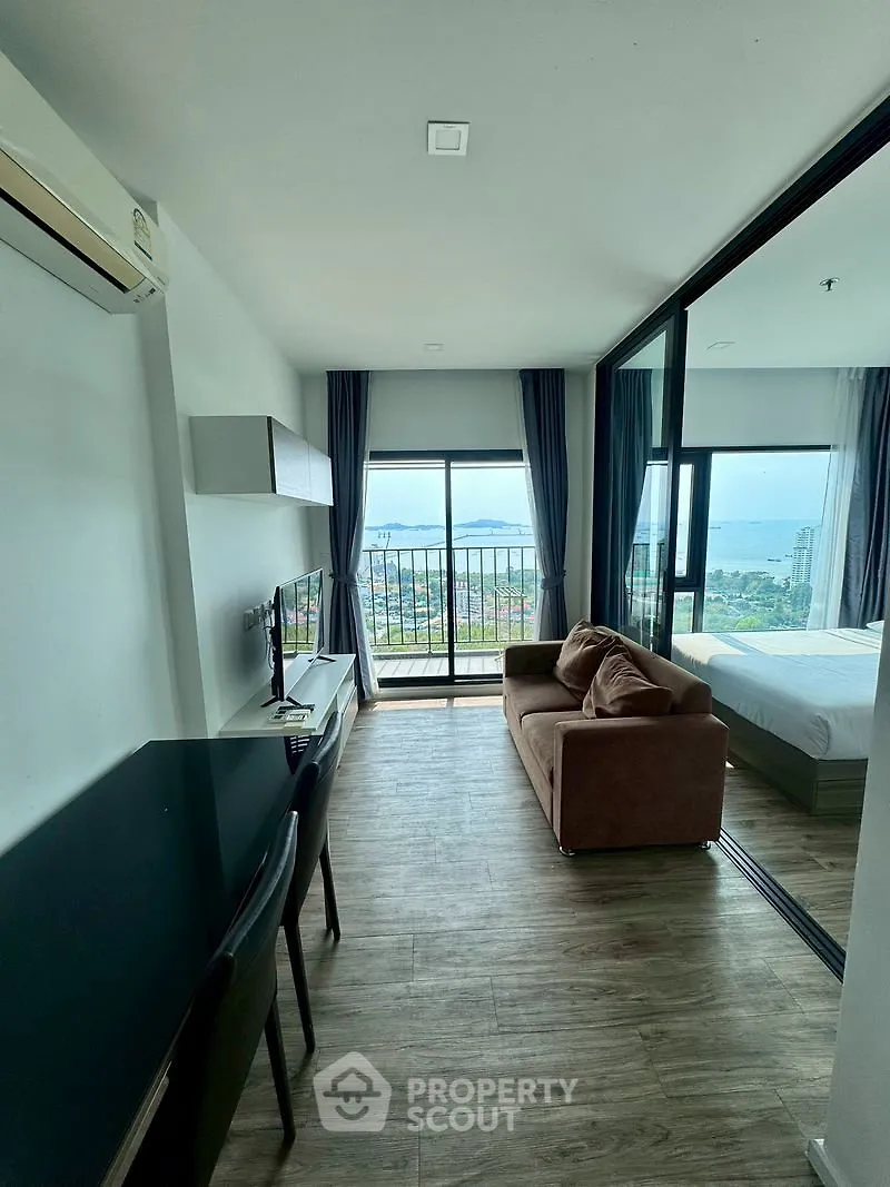 Modern living room with stunning ocean view and balcony access in a high-rise apartment.