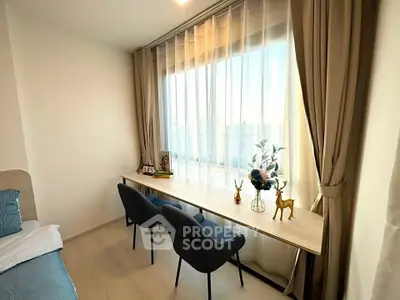Bright and cozy bedroom with large window and elegant decor, perfect for relaxation and work.