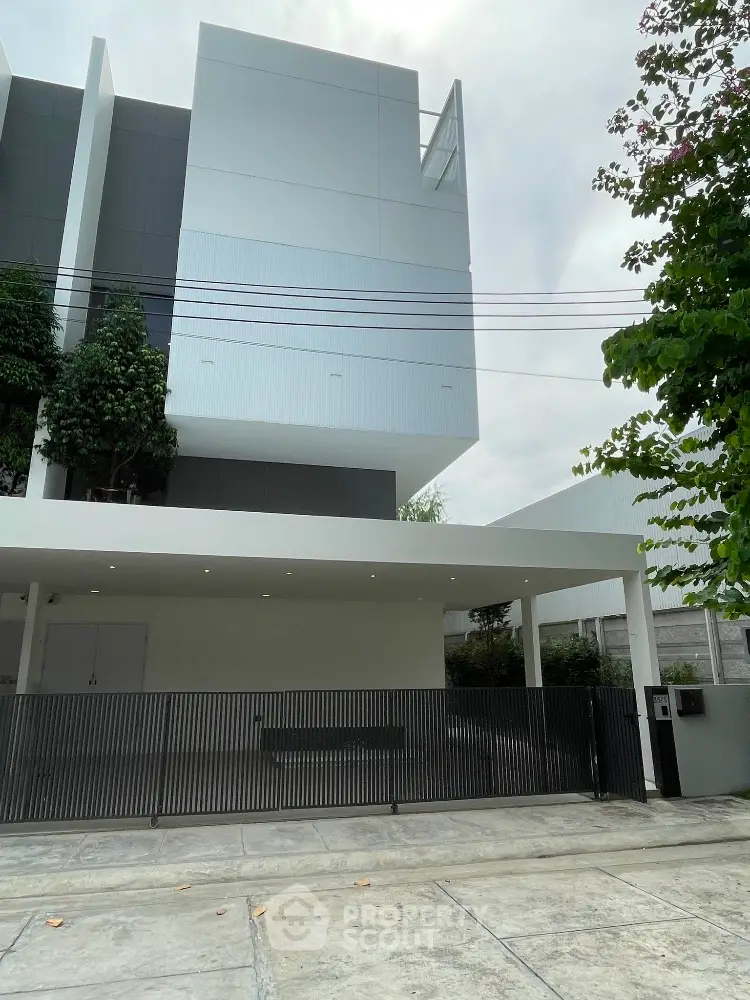 Modern minimalist white building exterior with sleek design and lush greenery