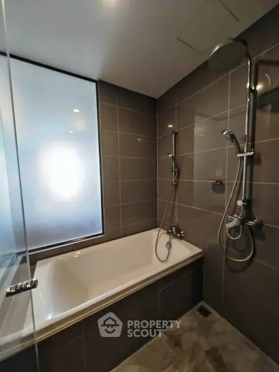 Modern bathroom with sleek design featuring a bathtub and dual shower heads.