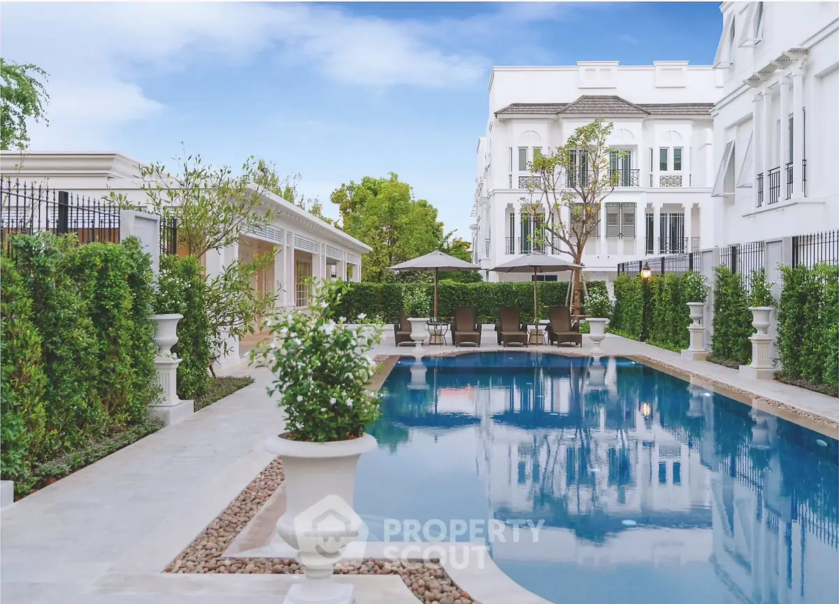 Luxurious residential pool area with elegant landscaping and classic architecture.