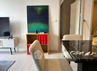 Modern living room with stylish furniture and abstract art, featuring a sleek TV setup and elegant dining area.