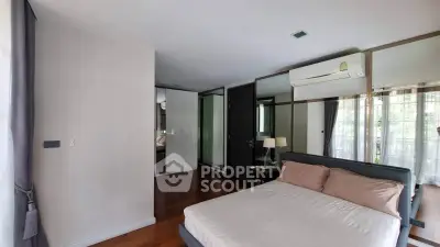 Spacious bedroom with modern decor and large windows offering natural light.