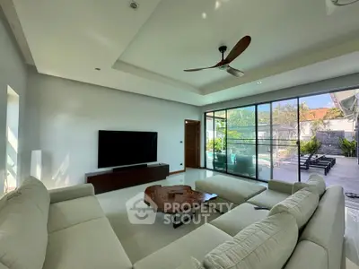Spacious modern living room with large windows and stylish furniture, offering a seamless indoor-outdoor experience.