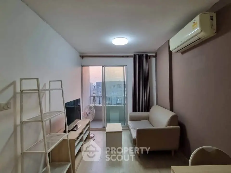 Modern living room with balcony view, air conditioning, and stylish furniture.