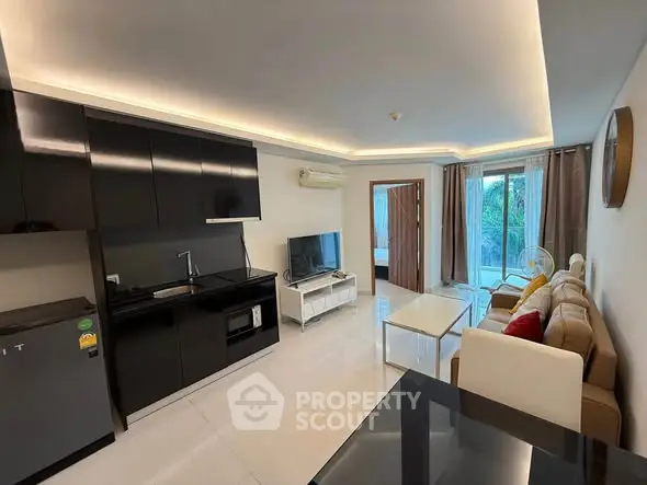Modern living room with sleek kitchen, cozy sofa, and natural light from large windows.