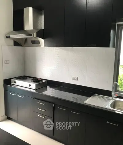 Modern kitchen with sleek black cabinetry and gas stove