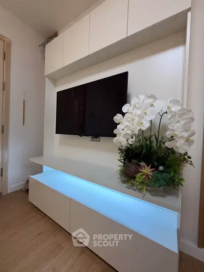 Modern living room with sleek TV unit and elegant floral arrangement