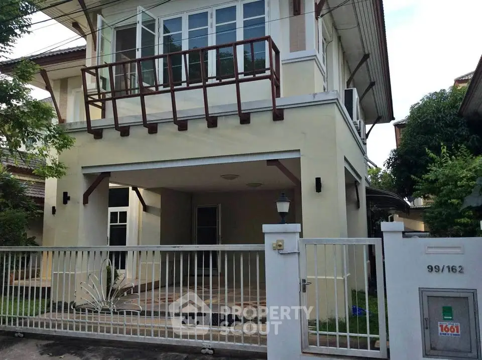 Charming two-story house with spacious balcony and gated entrance in a serene neighborhood.