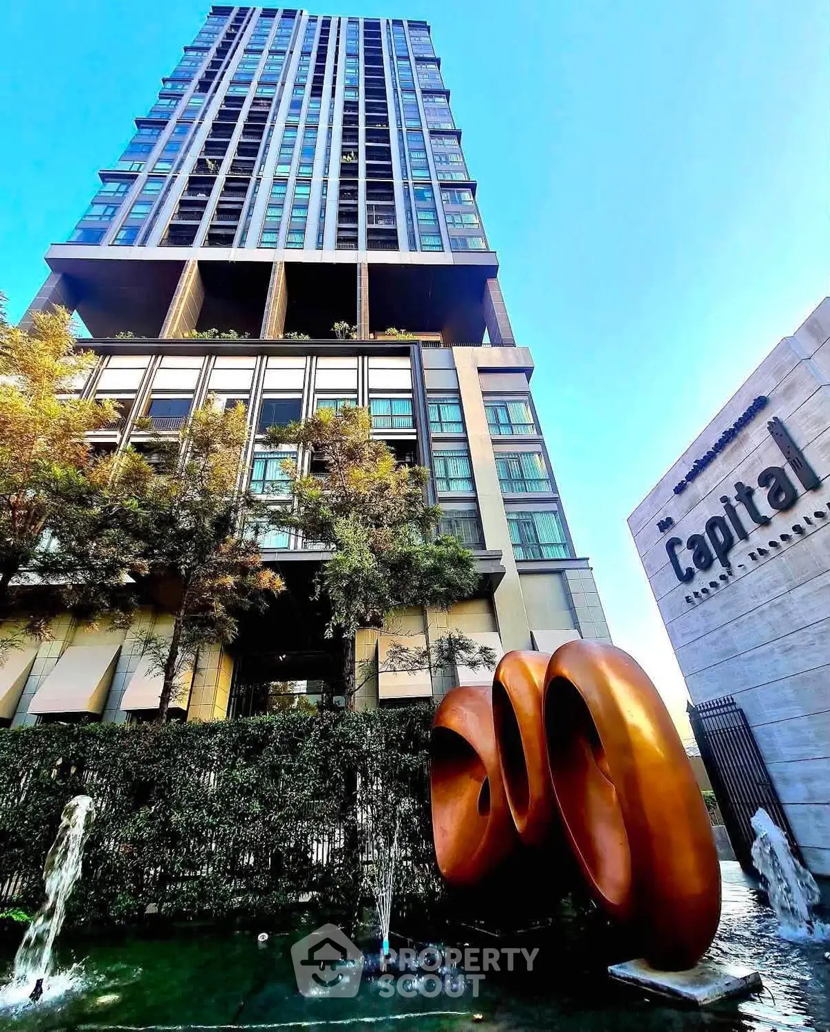 Stunning modern high-rise building with unique architectural design and lush landscaping.