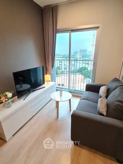 Modern living room with city view, featuring cozy sofa and TV setup, ideal for urban living.
