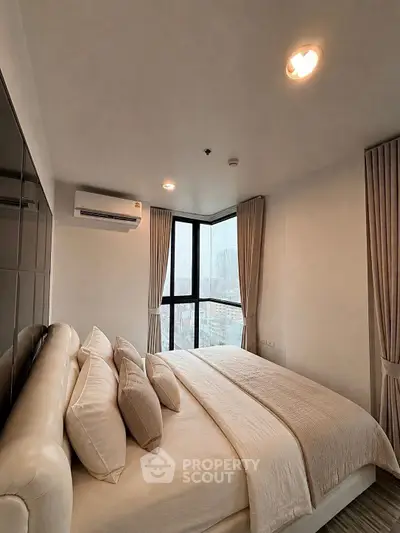 Luxurious bedroom with city view, featuring elegant decor and ample natural light.
