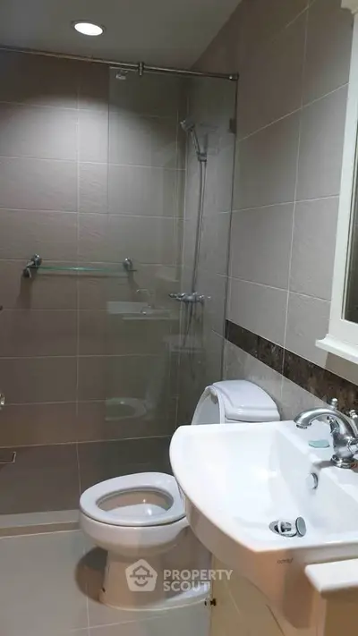 Modern bathroom with glass shower and sleek fixtures in a contemporary home.