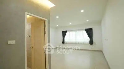 Spacious empty room with large window and elegant curtains, perfect for customization.