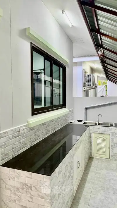 Modern outdoor kitchen with sleek countertops and tiled backsplash