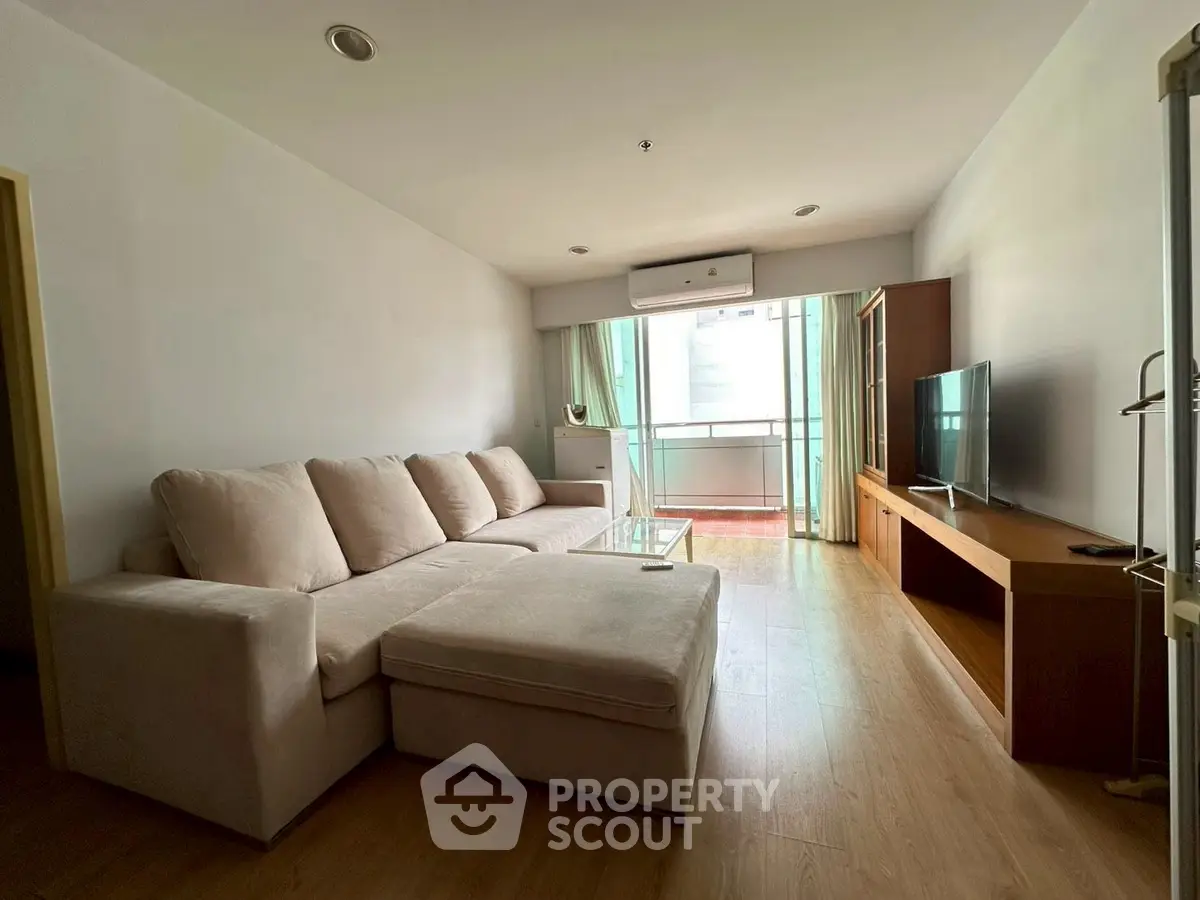 Spacious living room with modern sofa and large TV, perfect for relaxation.