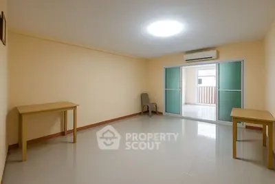 Spacious empty room with tiled floor and sliding glass doors.