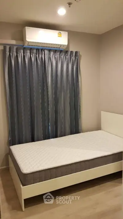 Cozy bedroom with single bed and air conditioning, perfect for a comfortable stay.