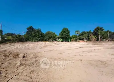 Expansive land plot with clear blue sky, ideal for development opportunities.