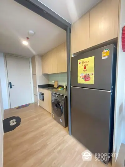 Modern kitchen with sleek appliances and wooden cabinetry in a stylish apartment.