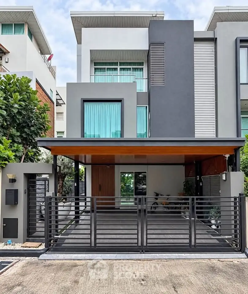 Modern luxury townhouse with sleek facade and gated entrance in urban setting.