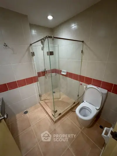 Modern bathroom with glass shower enclosure and tiled flooring