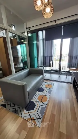 Modern living room with stylish decor and balcony view, featuring a cozy sofa and chic lighting.