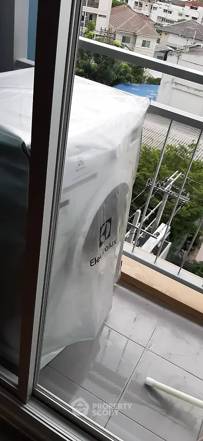 Modern balcony with washing machine and city view, perfect for urban living convenience.