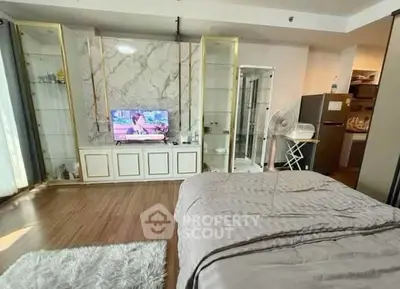 Spacious bedroom with modern decor and TV, featuring a cozy bed and stylish flooring.