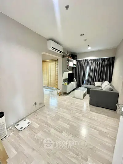 Modern living room with sleek design, featuring a cozy sofa, stylish entertainment unit, and elegant flooring.