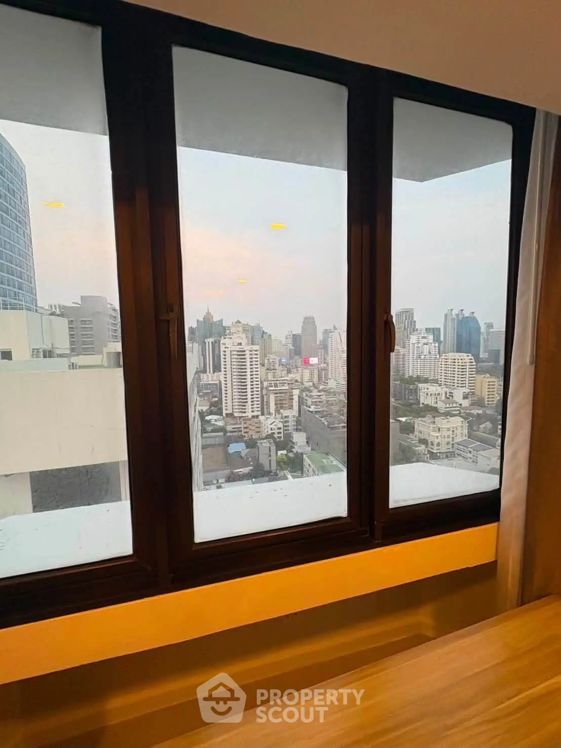 Stunning cityscape view from a high-rise apartment window, showcasing urban skyline.