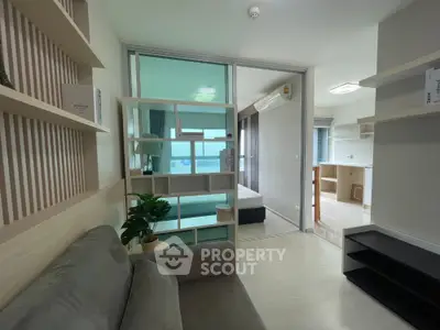 Modern apartment interior with cozy living room and bedroom, featuring stylish shelving and natural light.