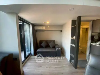 Modern compact living room with balcony access and sleek design.