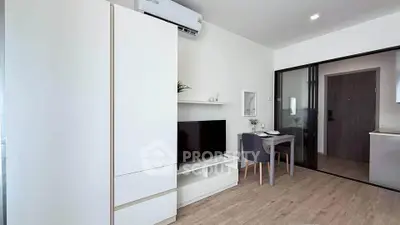Modern living room with sleek furniture and dining area in a stylish apartment.