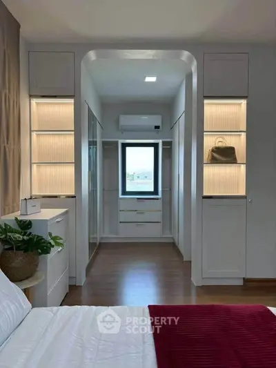 Luxurious bedroom with walk-in closet and elegant lighting, showcasing modern interior design and spacious layout.