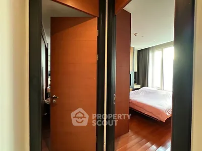 Spacious bedroom with wooden flooring and large windows for natural light