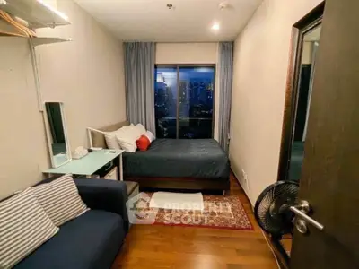 Cozy bedroom with city view, featuring a comfortable bed, sofa, and elegant decor.