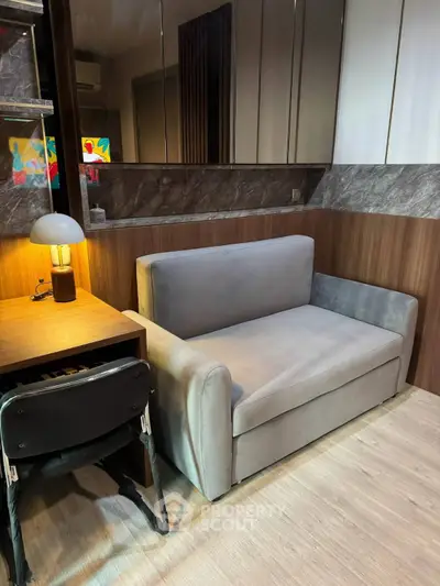 Modern living room with sleek sofa and stylish desk, perfect for urban living.