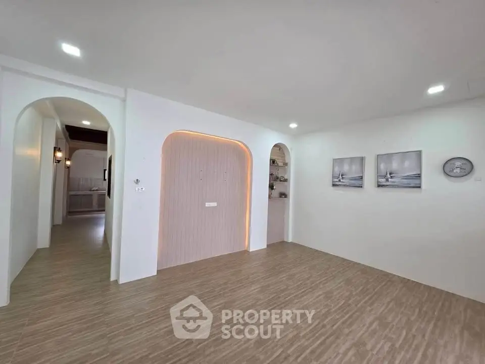 Spacious modern living room with elegant arches and stylish decor.