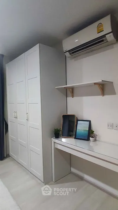 Modern bedroom with sleek white wardrobe and air conditioning unit