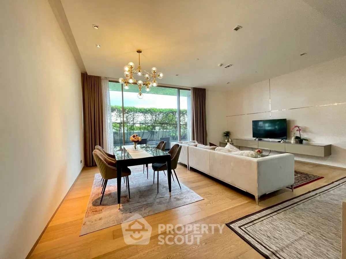 Spacious modern living room with elegant dining area and large windows overlooking greenery.