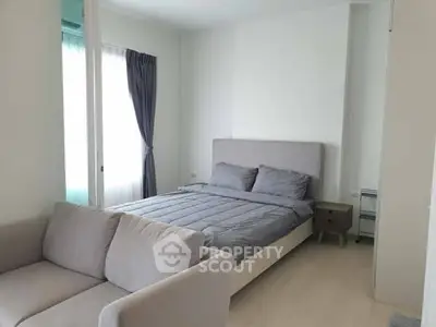 Modern bedroom with cozy bed and stylish sofa in bright apartment