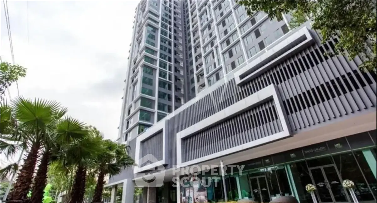 Modern high-rise building with sleek architectural design and lush greenery.