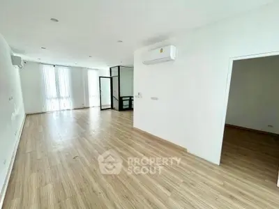 Spacious modern living room with wooden flooring and large windows