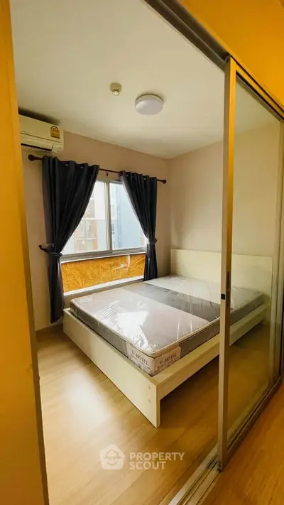 Cozy bedroom with natural light and modern furnishings in a stylish apartment.